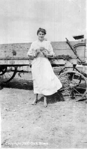 Grace Taylor on the Phillips farm holding two piglets, Castner Falls, Cascade County, Montana