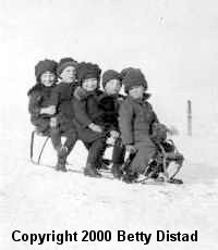 5 kids coasting along on a sled